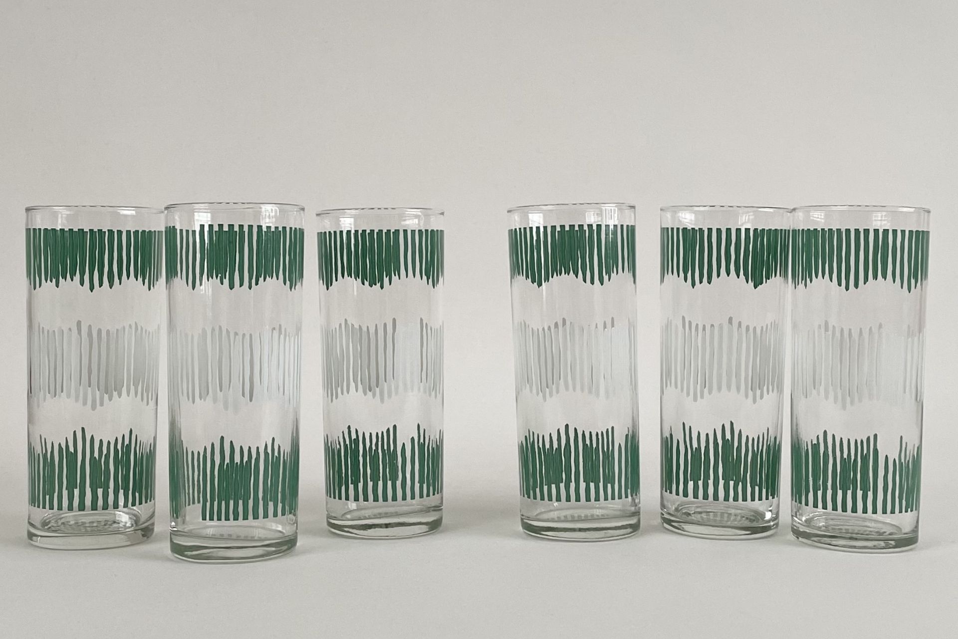 Clear highball glasses with a green and white etched design