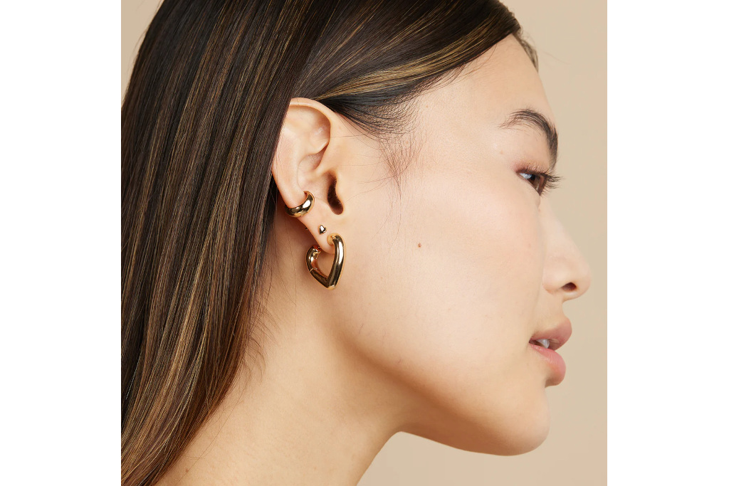 Woman wearing gold heart hoop