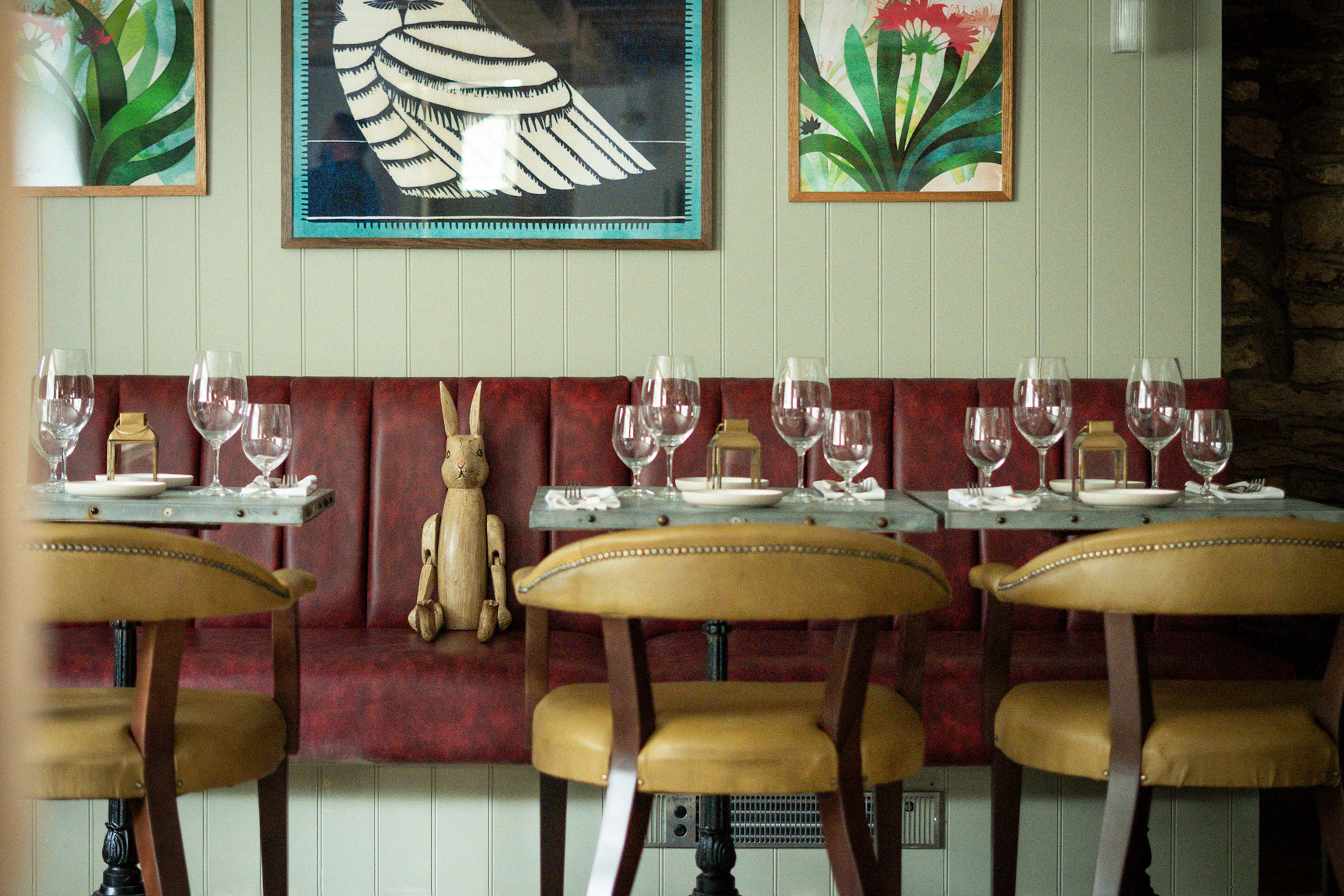 Gastropub dining room with red banquette seating and wooden chairs.
