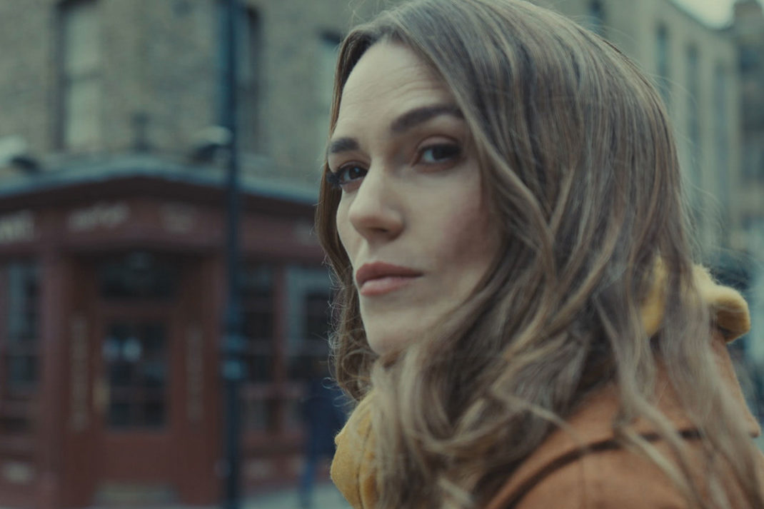 Keira Knightley in London, wearing a mustard yellow jacket.