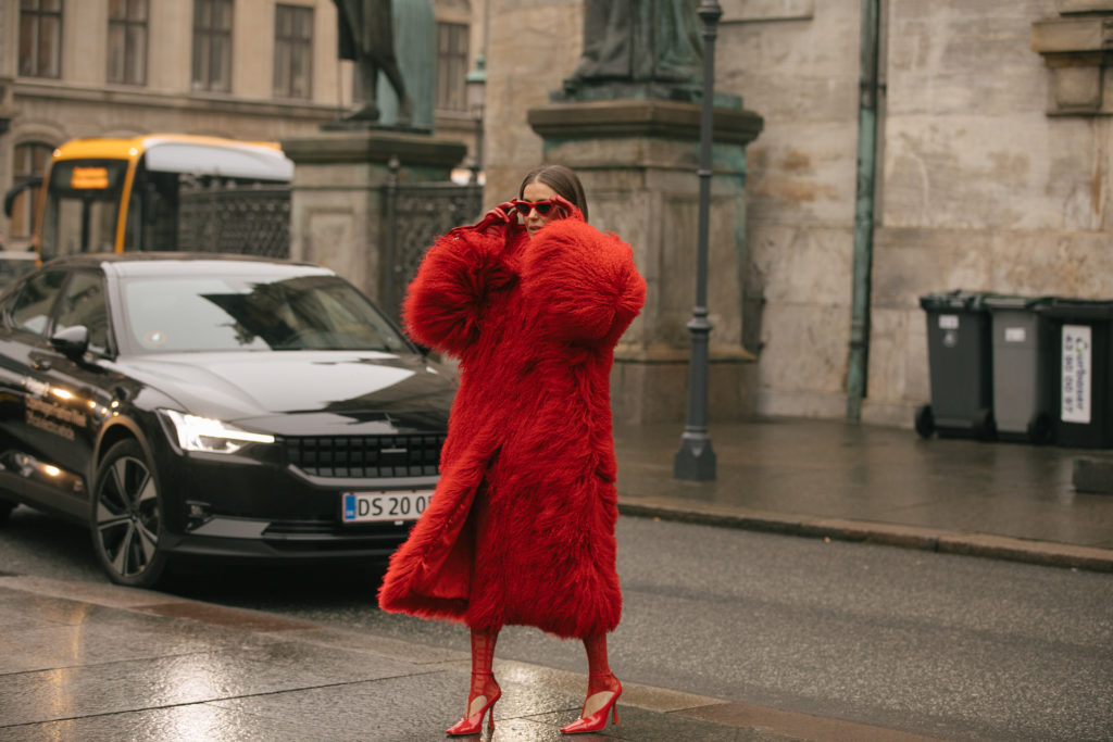 Woman in red fluffy coat crossing road