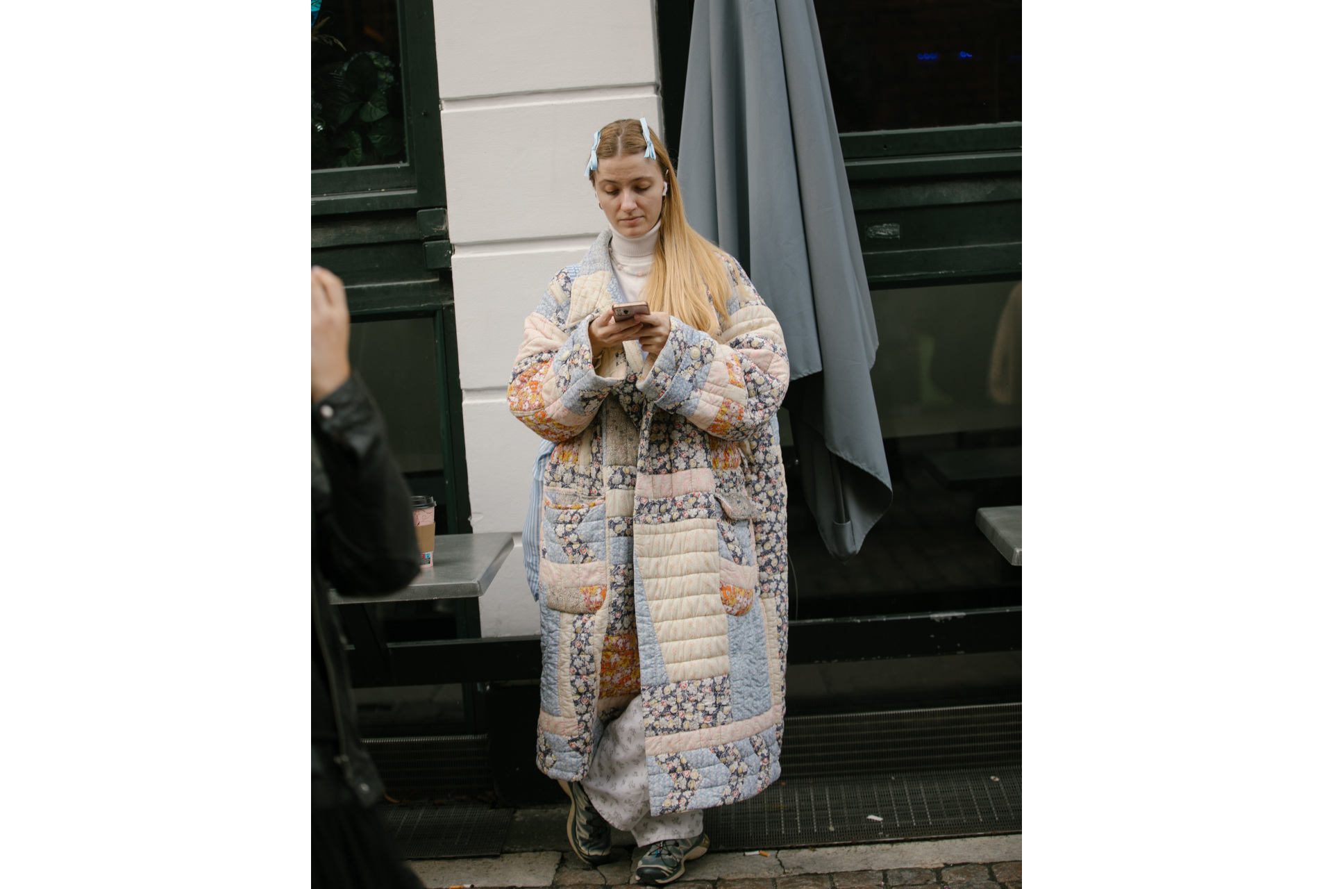 Woman in patchwork coat with bows in her hair