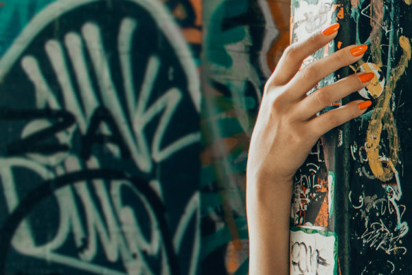 Hand with orange almond nails