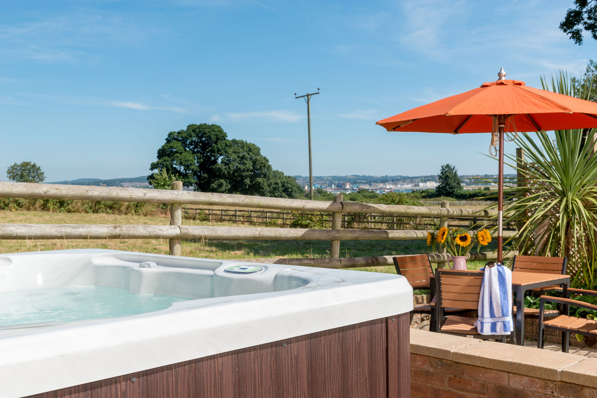 Hot tub with estuary view and orange parasol.