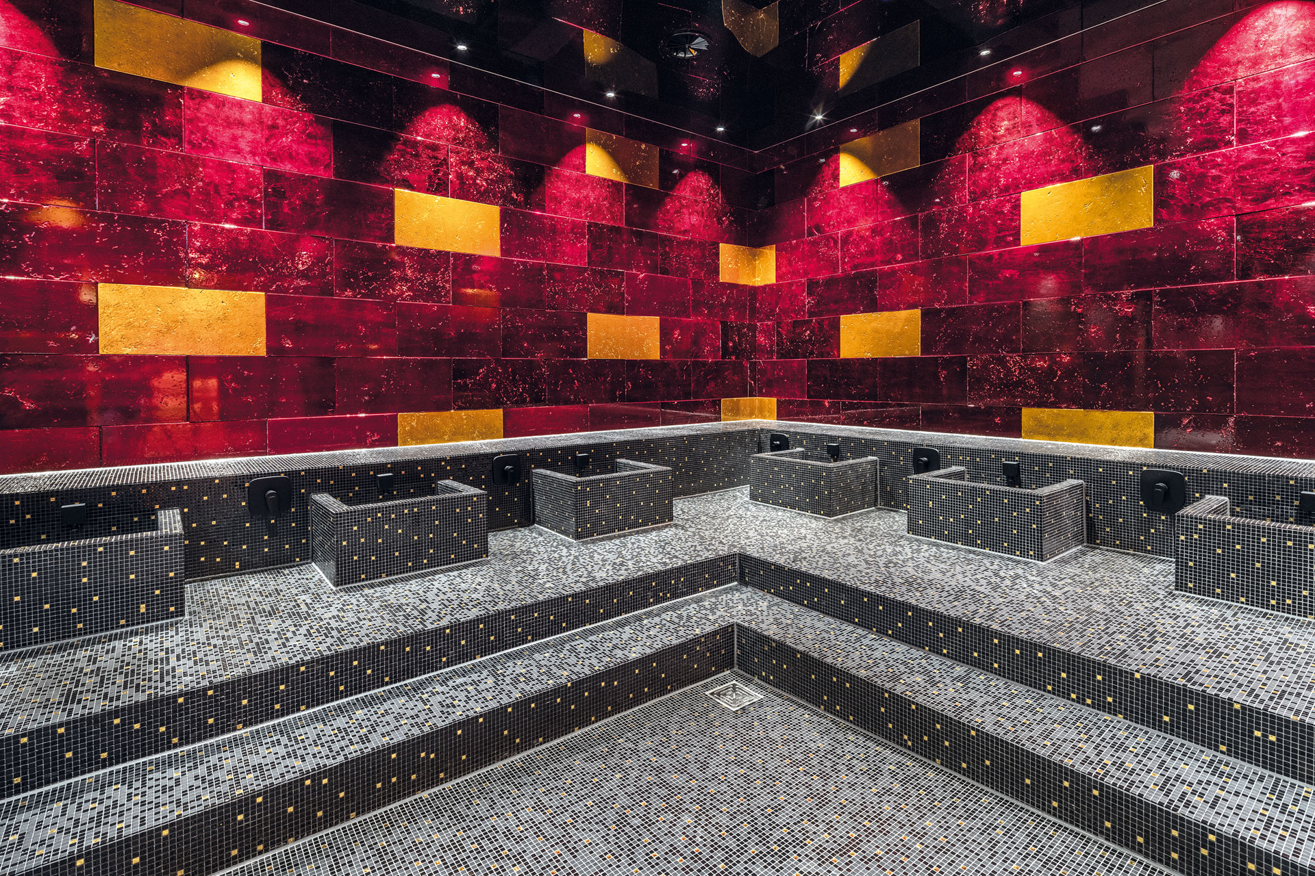 Sauna with red tiles and grey seating.