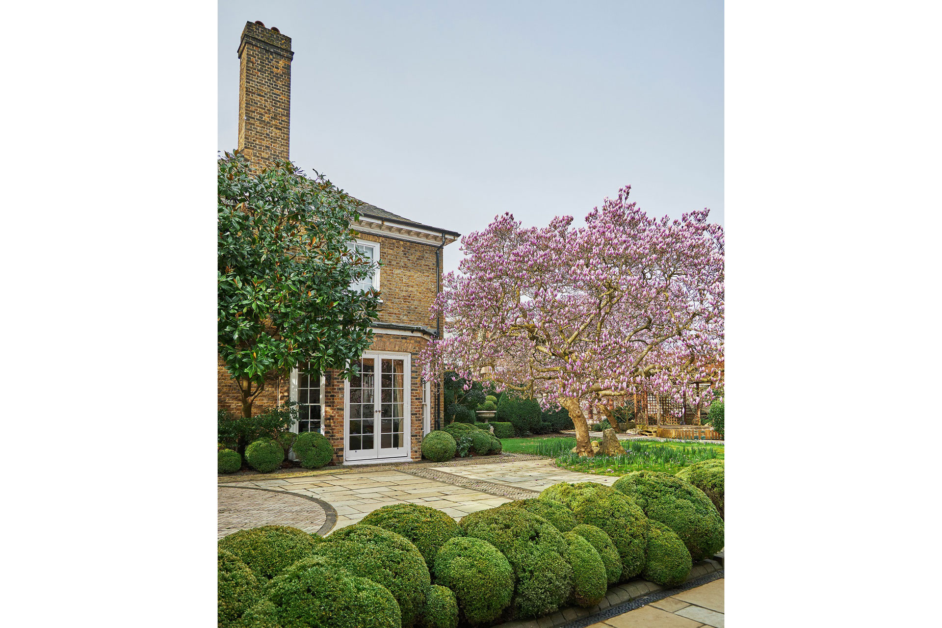 Neo-Georgian Kensington mansion with patio and magnolia trees.