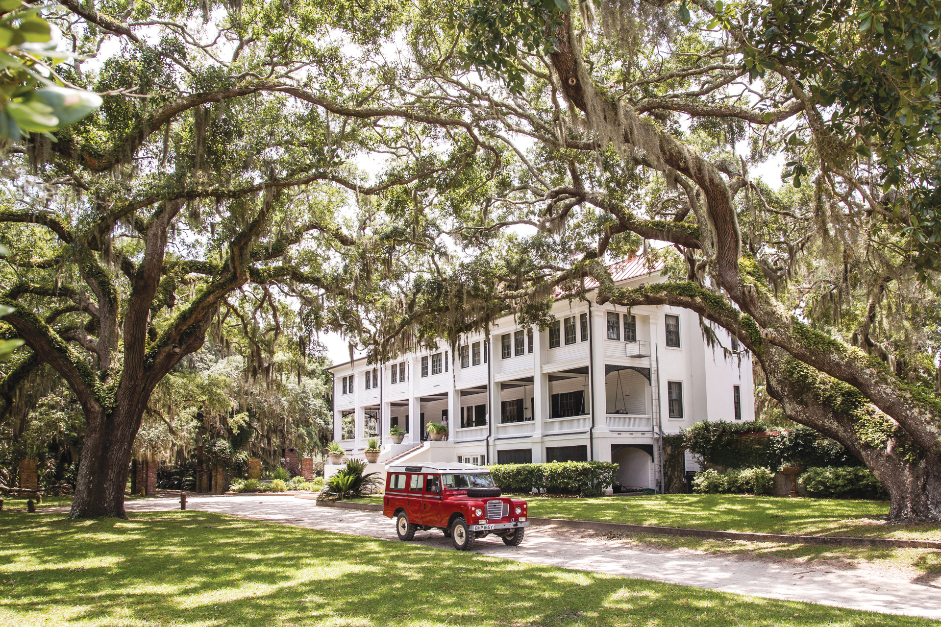 The exterior of Greyfield Inn with a red Land Rover