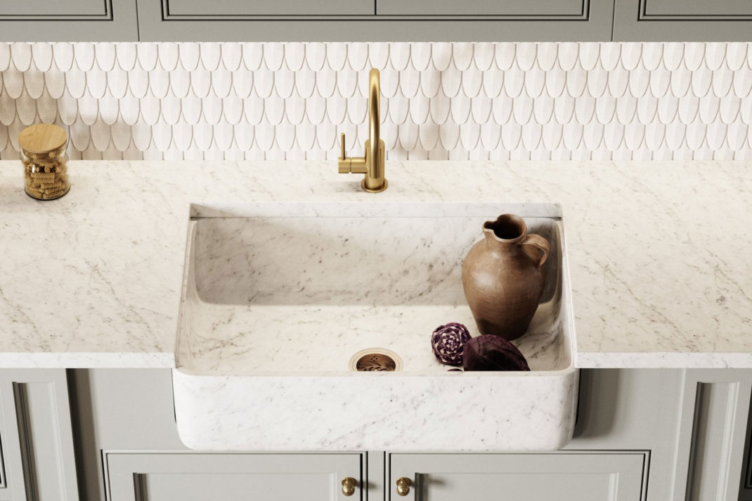 White marble integrated sink with grey shaker style kitchen cupboards and a white scalloped tile backsplash behind.l