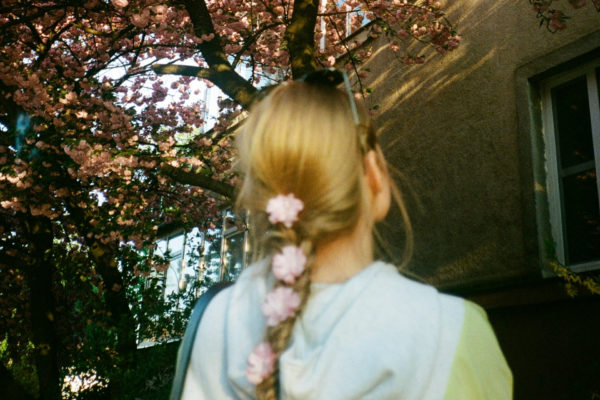 Back of woman's head, she has flowers in her braid | floral hair trend