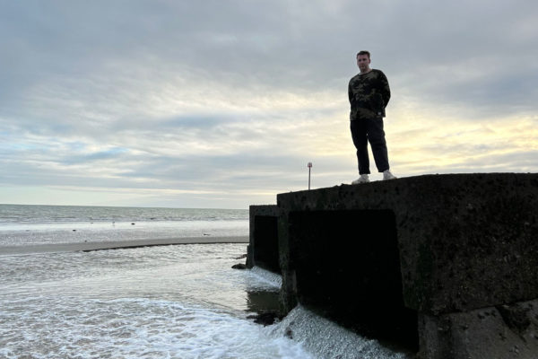Joe Lycett standing by the water