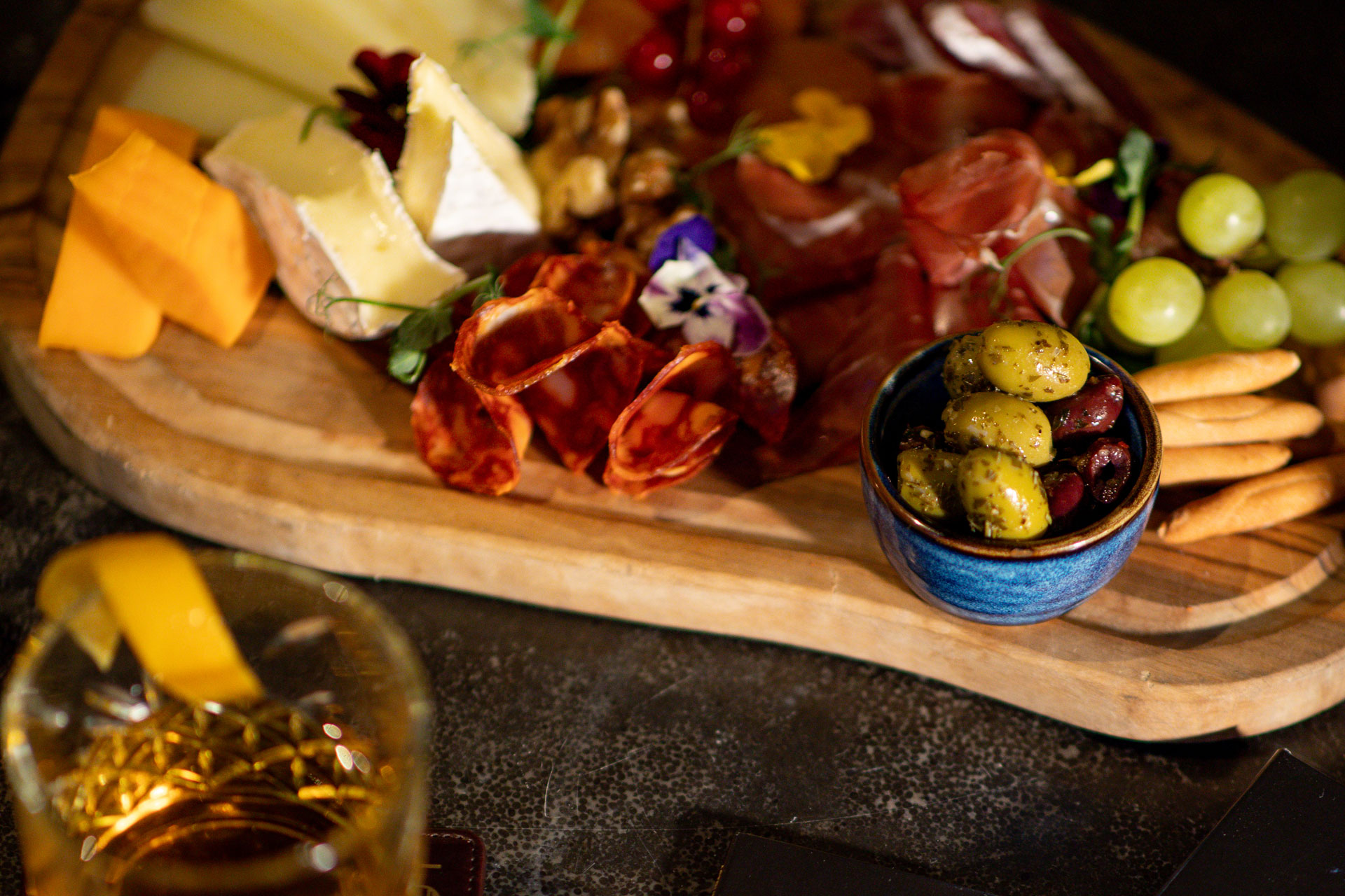 Charcuterie board with a bourbon cocktail.