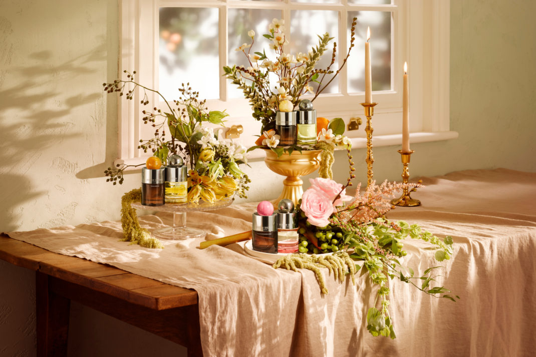 Fragrance bottles scattered on table with cases of flowers