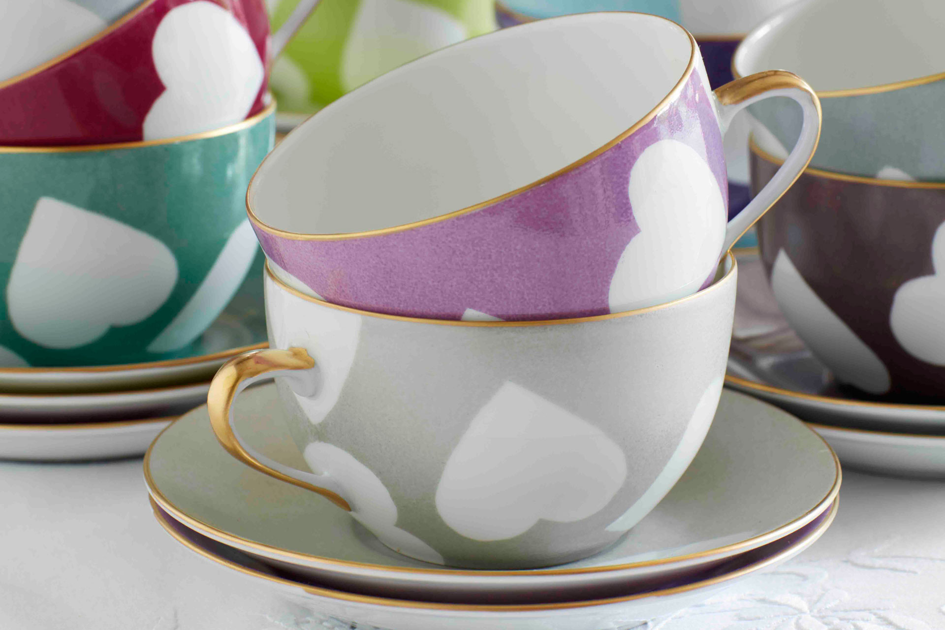 Grey and mauve hand-painted cups with white hearts.