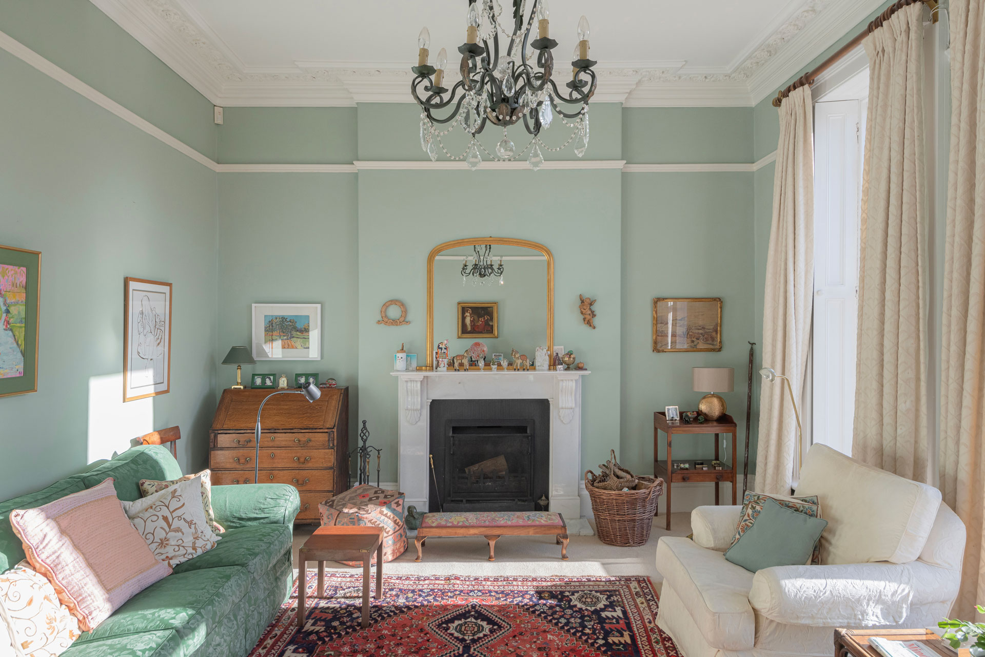 Living room with pastel blue walls, white sofas and a chandelier.