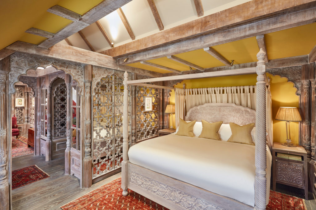 Hotel suite with four poster bed, lattice walls and patterned rugs