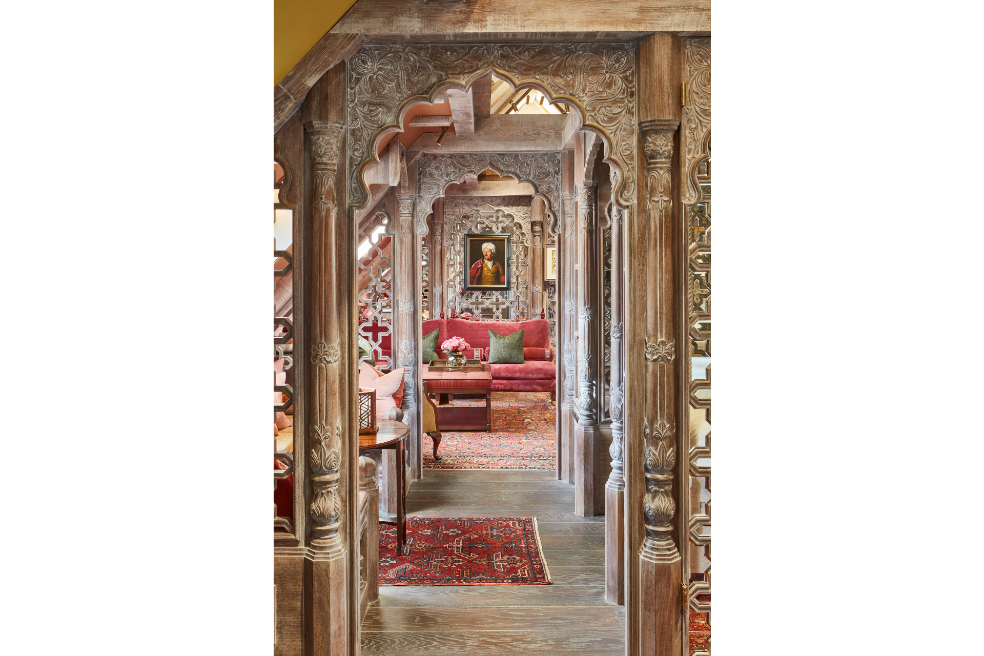 Hallway bordered by ornate arches with portrait at the end