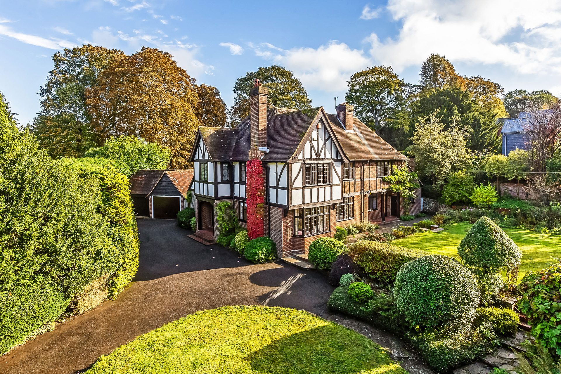 Large timber-framed country home with lawns behind.