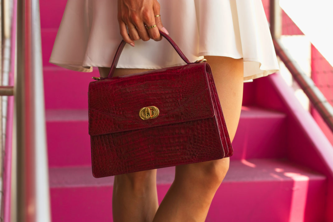 Close-up of someone holding red designer bag