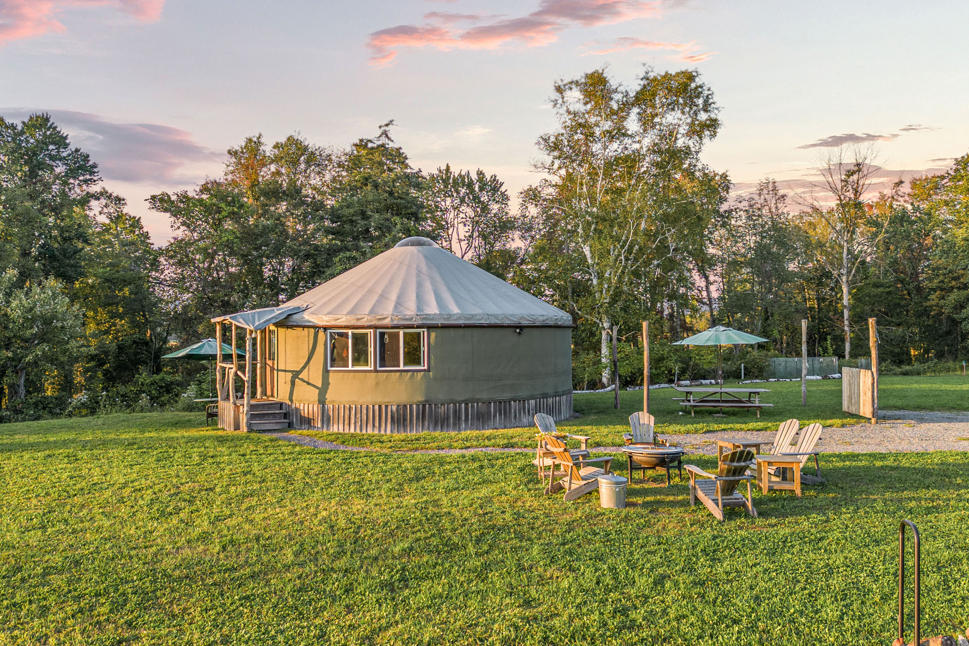 Wooden yurt with wooden chairs in field