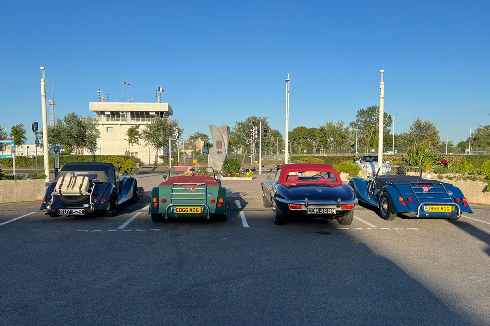 Classic cars parked in a row in a car park in France.