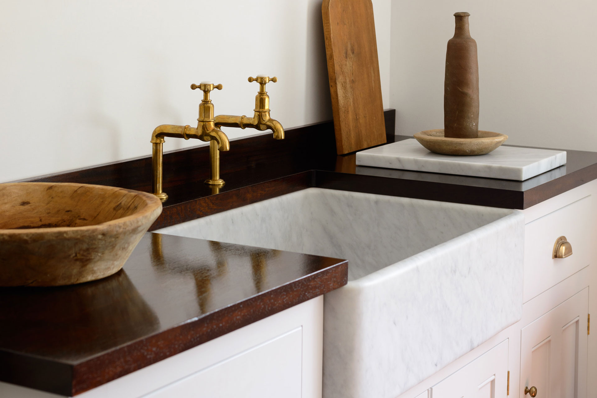 Countertop with marble sink and brass taps.