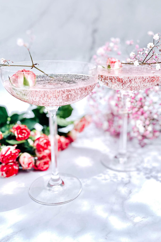 Two glasses of pink champagne with roses
