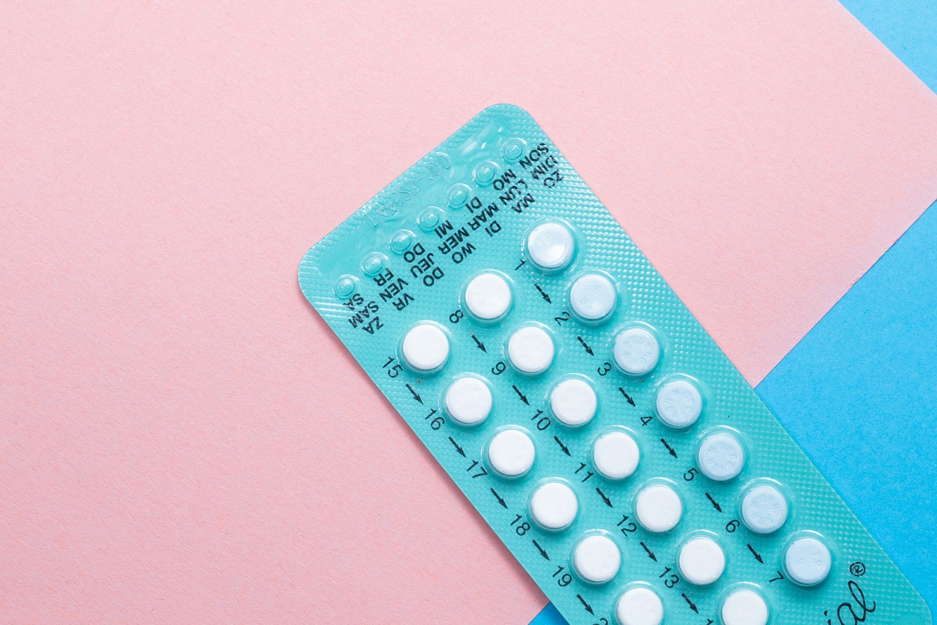 The contraceptive pill on a pink and blue background