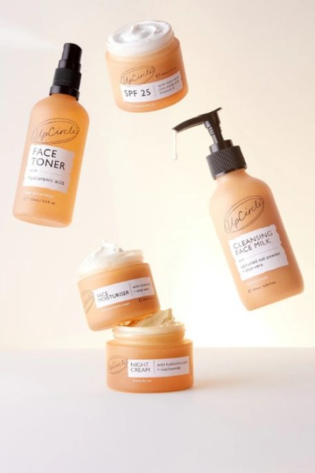 Skincare bottles from British B Corp beauty brand UpCircle thrown mid-air