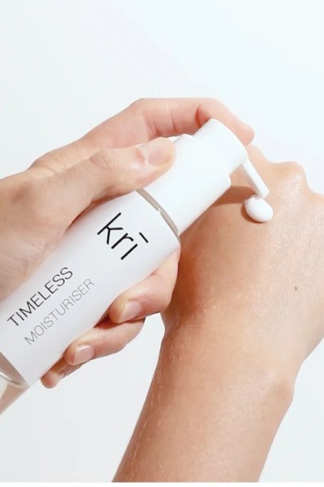 Close up of hands holding and applying moisturiser to hand