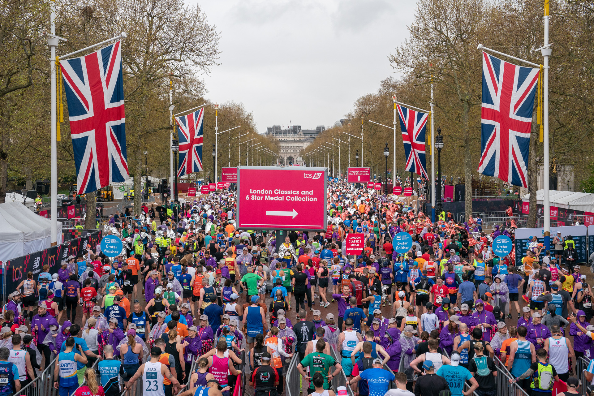 Runners stream through the medal gates on The Mall during The TCS London Marathon on Sunday 23rd April 2023