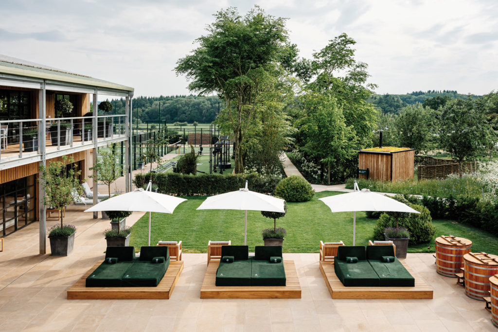 Aerial view of the Bamford Club garden, with green sun loungers and white parasols