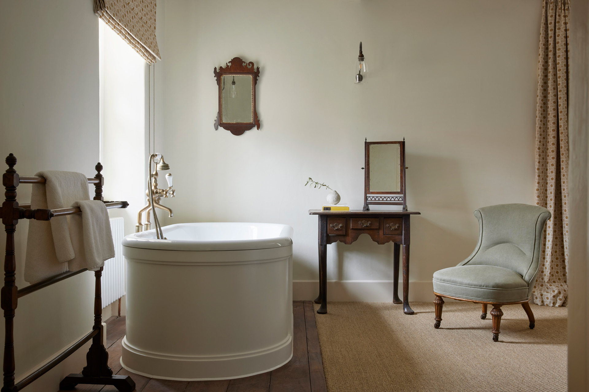Bathroom with freestanding bath, wooden chair and wood-framed mirror