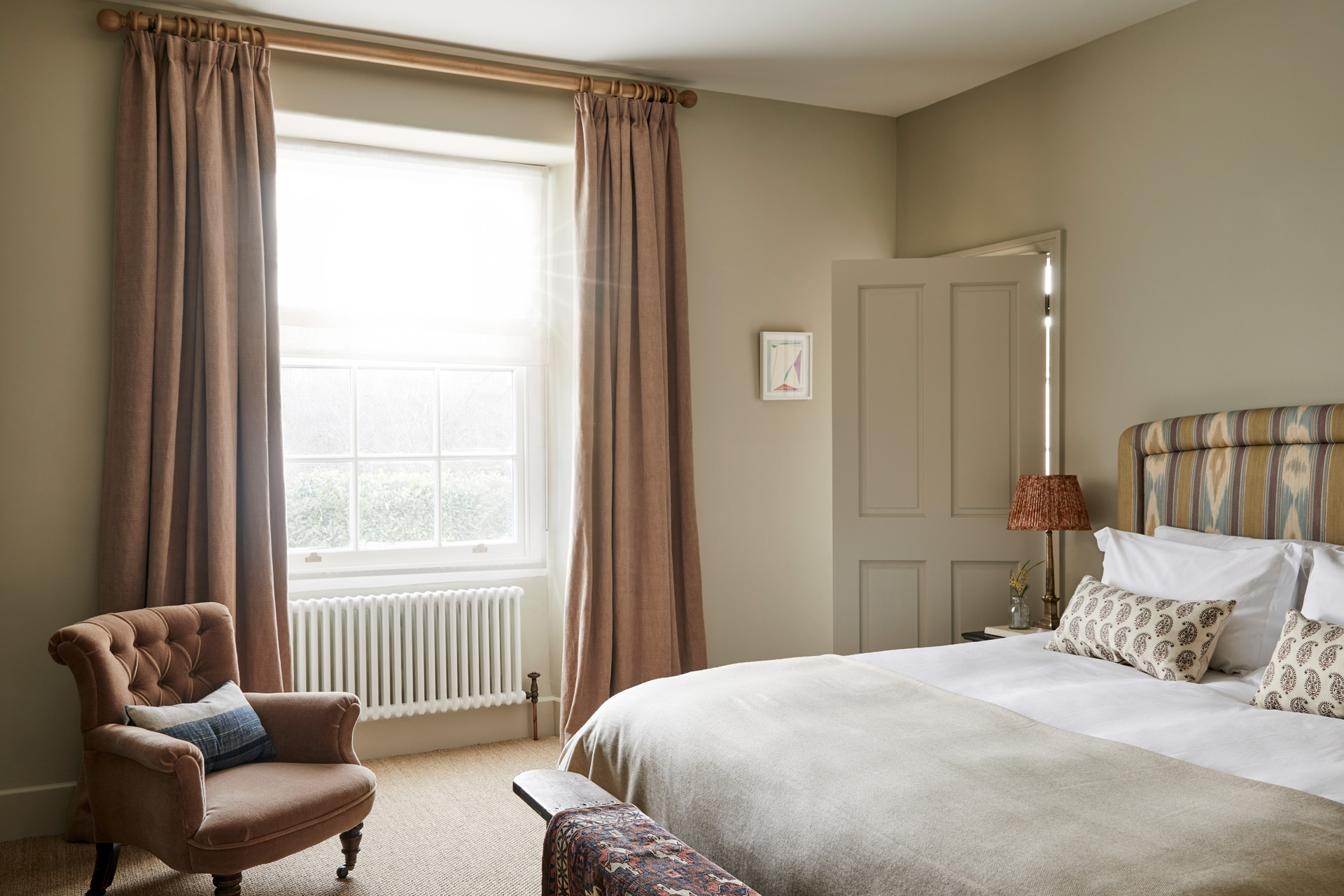 Bedroom with taupe and orange colour palette.