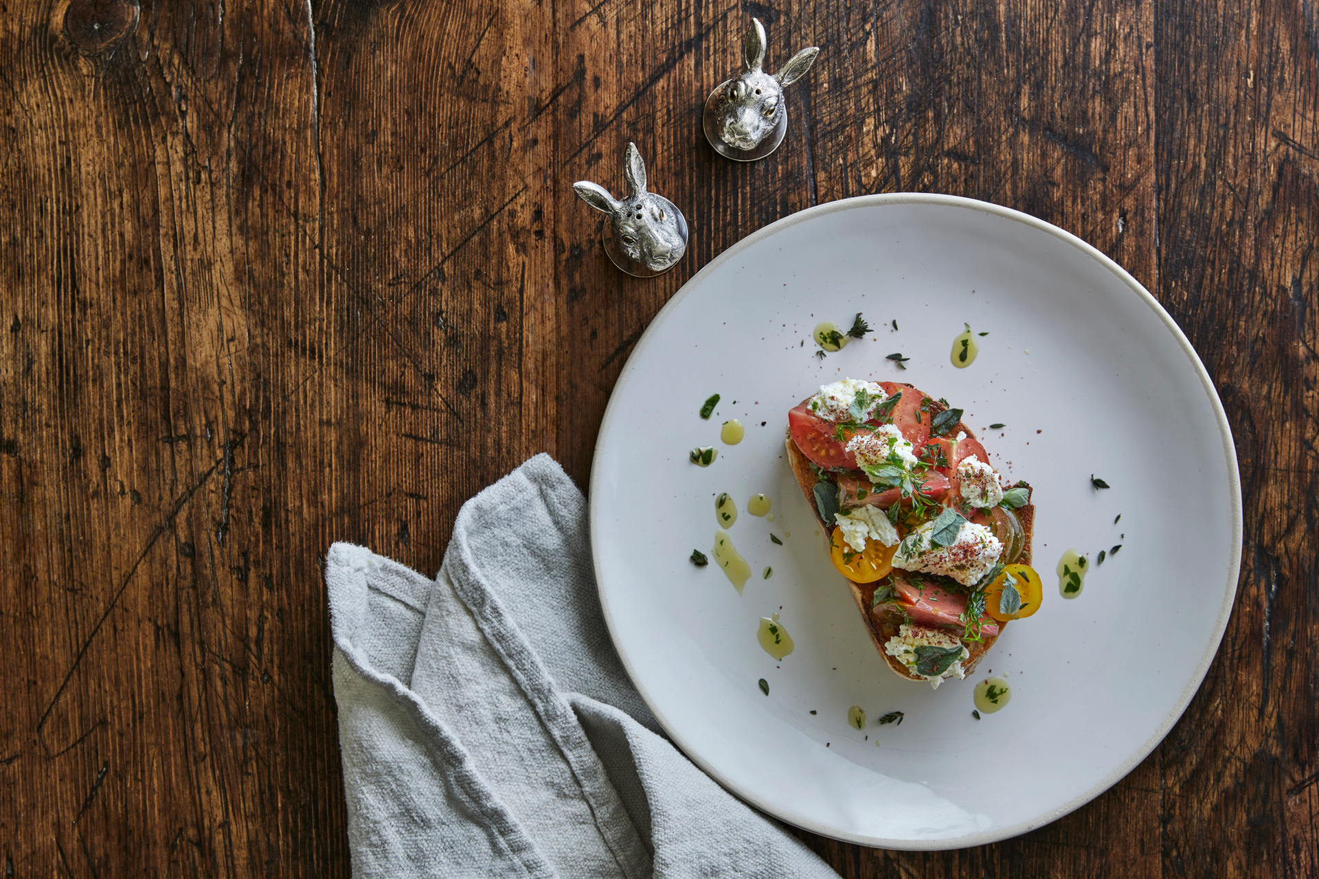 Plate of bruschetta with salt and pepper shakers beside it.