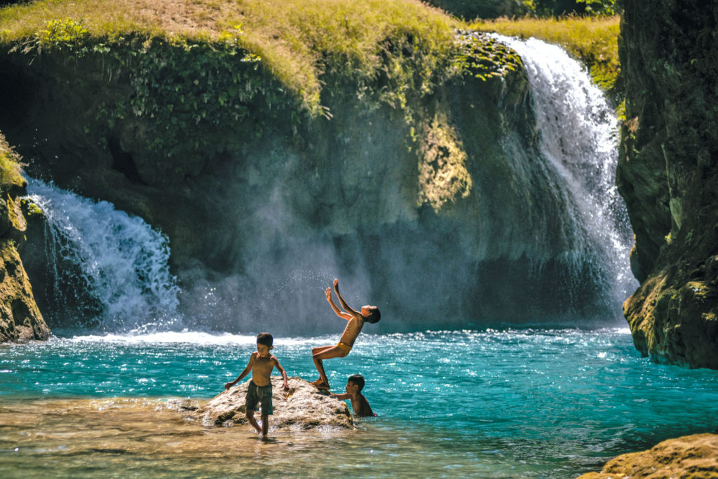 Children playing by a waterfall in Sumba