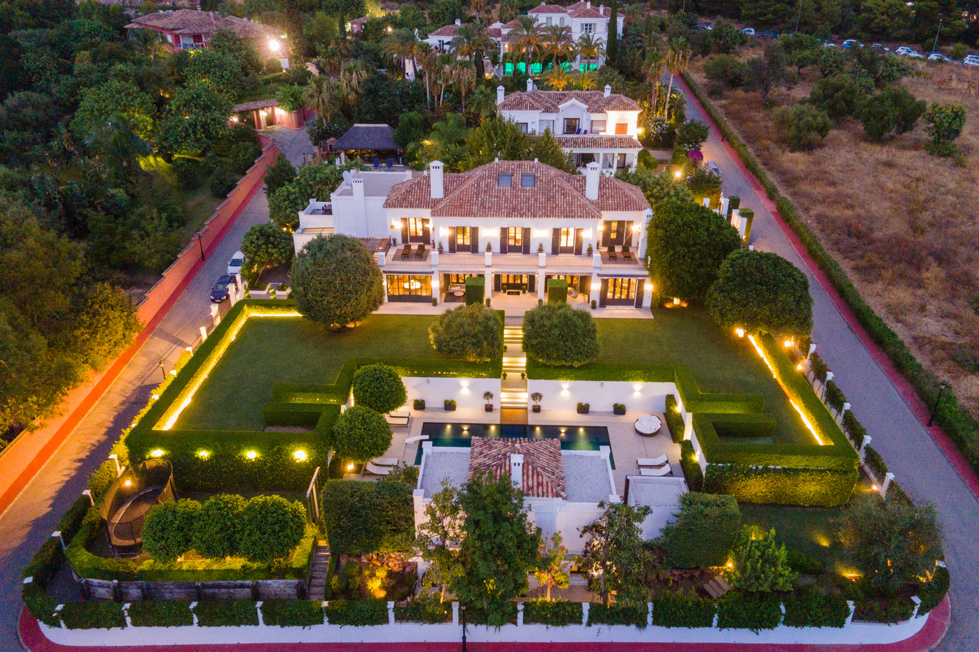 Aerial view of Spanish villa with landscaped gardens, outhouses and a pool.