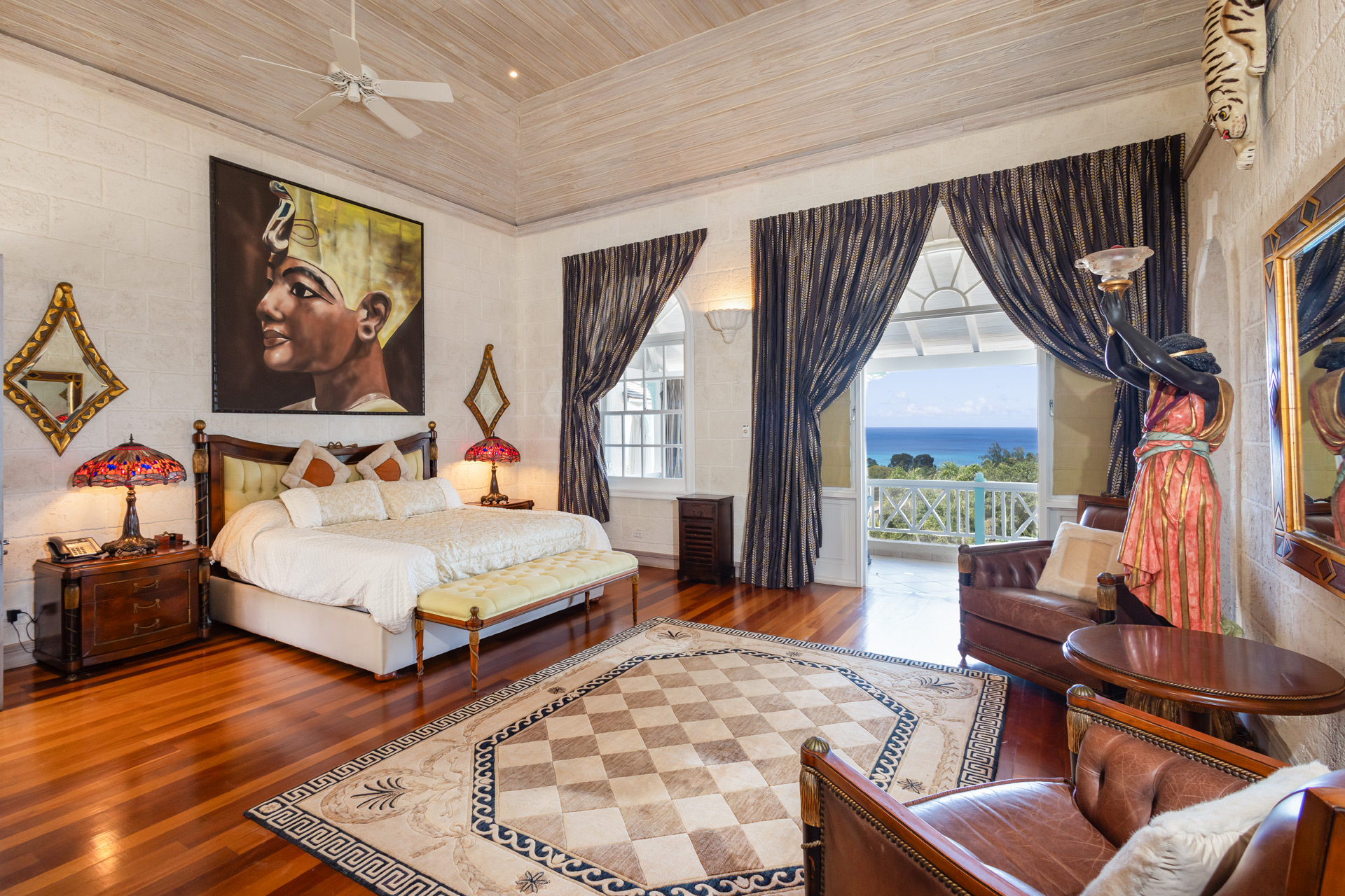 Villa bedroom, with king-size bed, armchair and views of the Caribbean Sea.