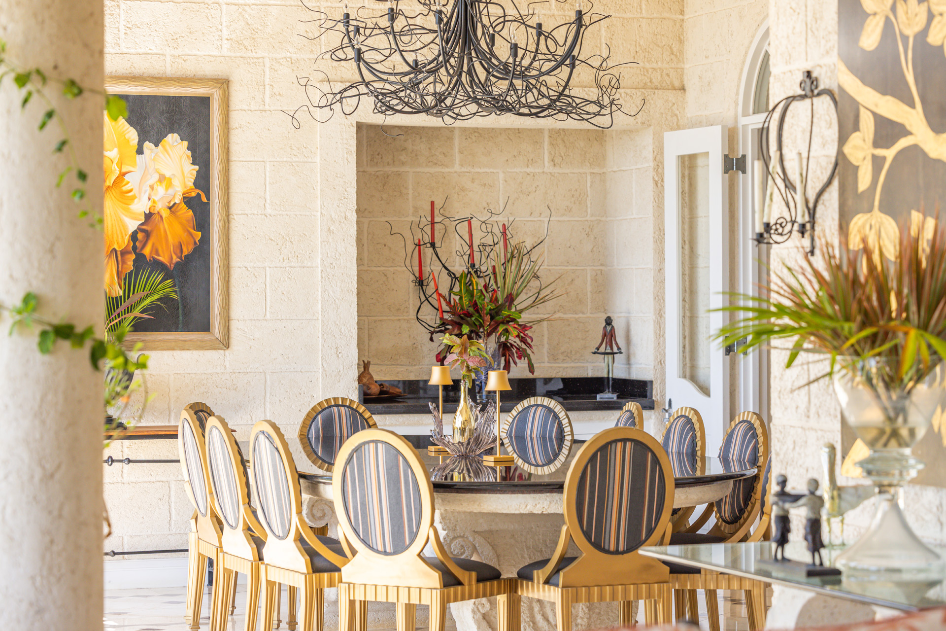 Outdoor dining area with gold-framed chairs and marble tiles.