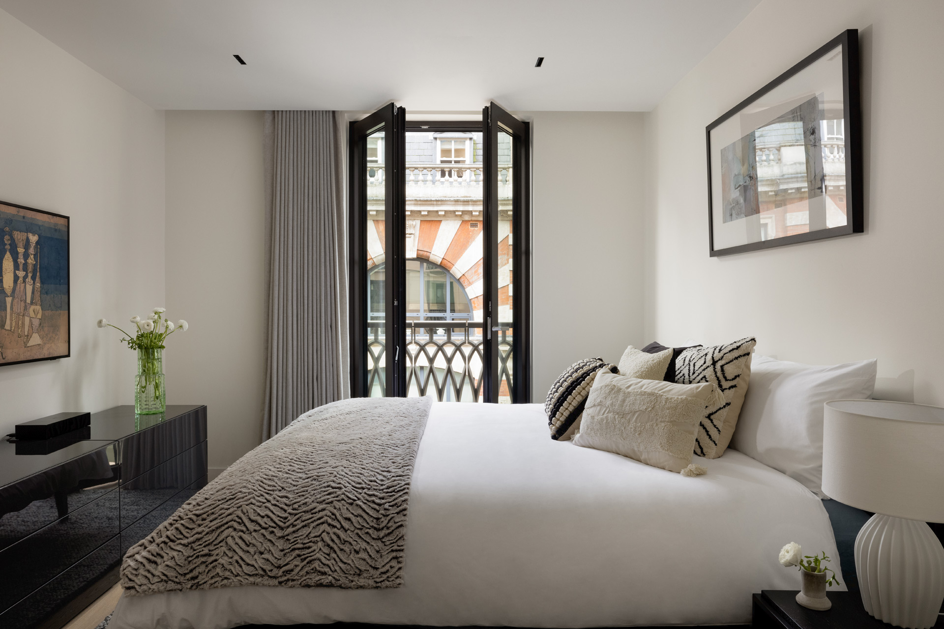 Bedroom with taupe accents and floor-to-ceiling windows.