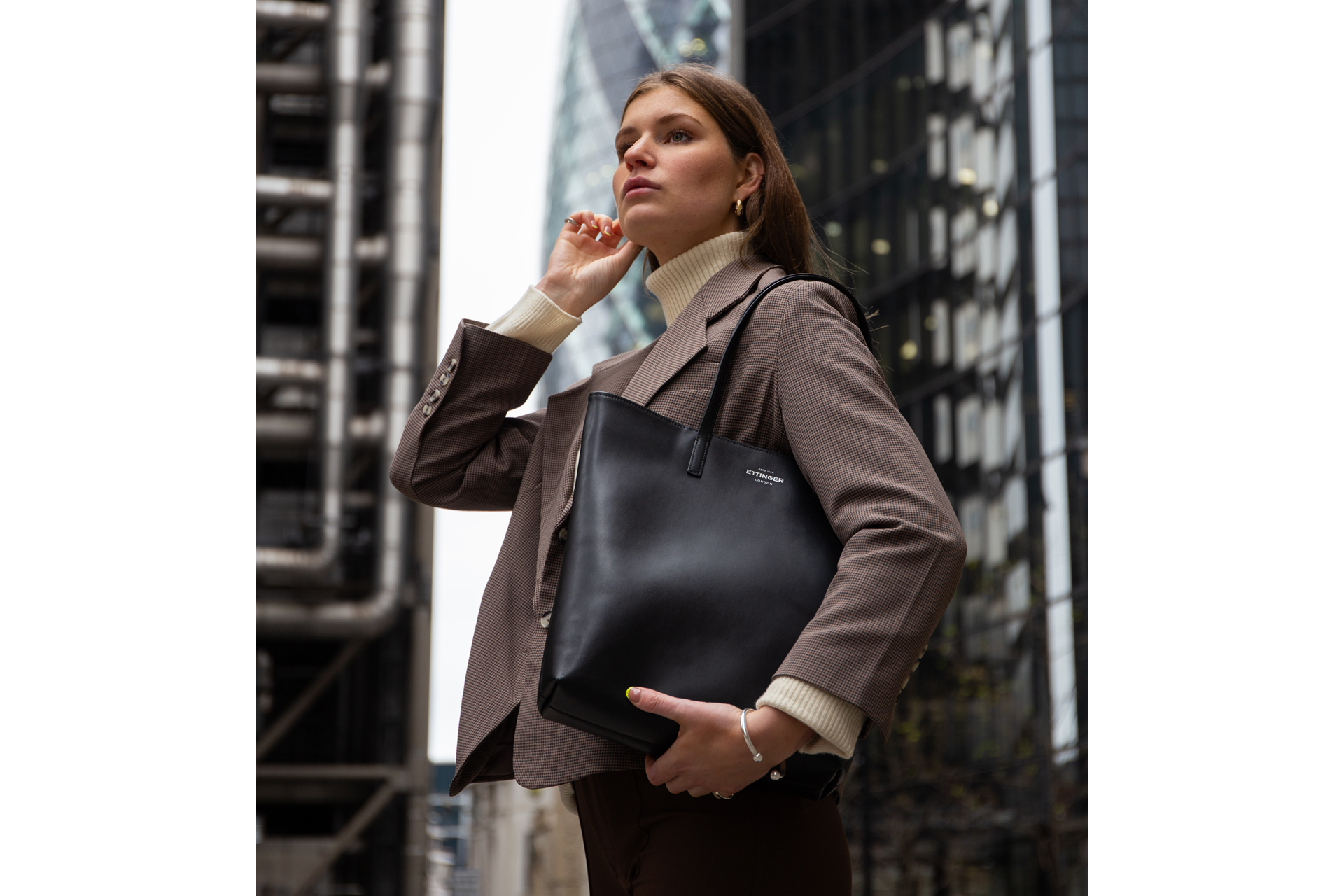 Blonde model carries Ettinger tote bag in city of london