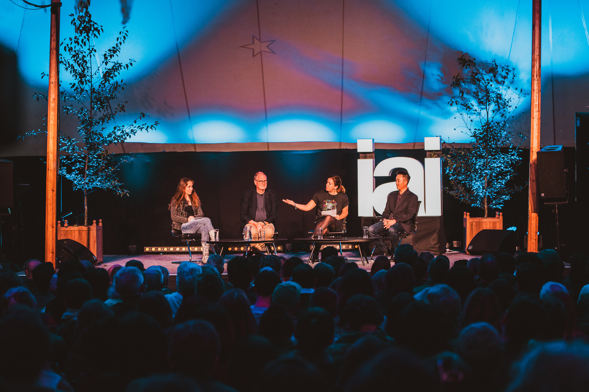 Four people on a stage delivering a talk