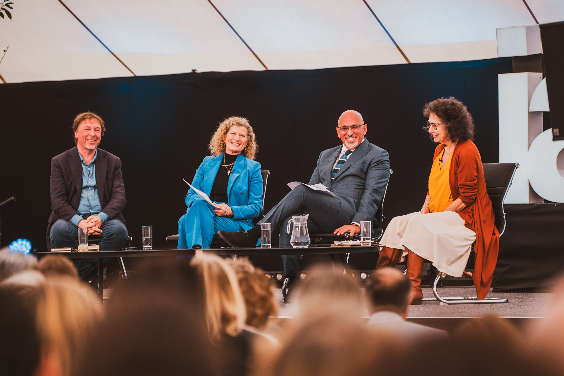 Four people on a stage delivering a talk