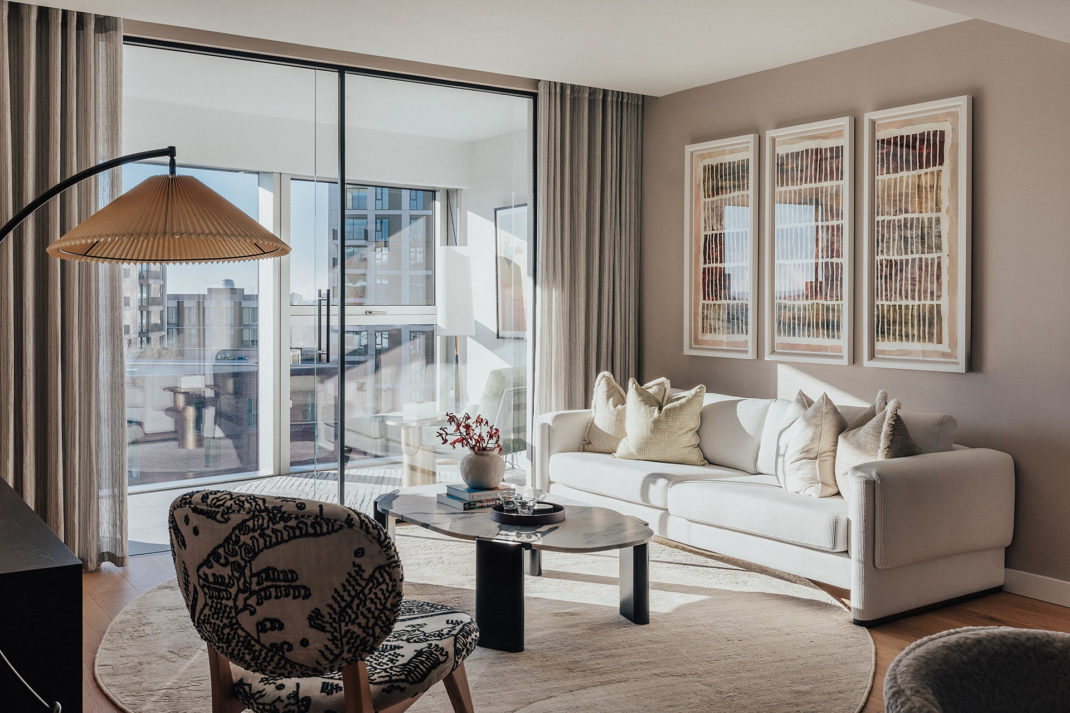 House of Vara collection at Koa, Electric Boulevard, with a marble coffee table, white sofa and patterned amrchair