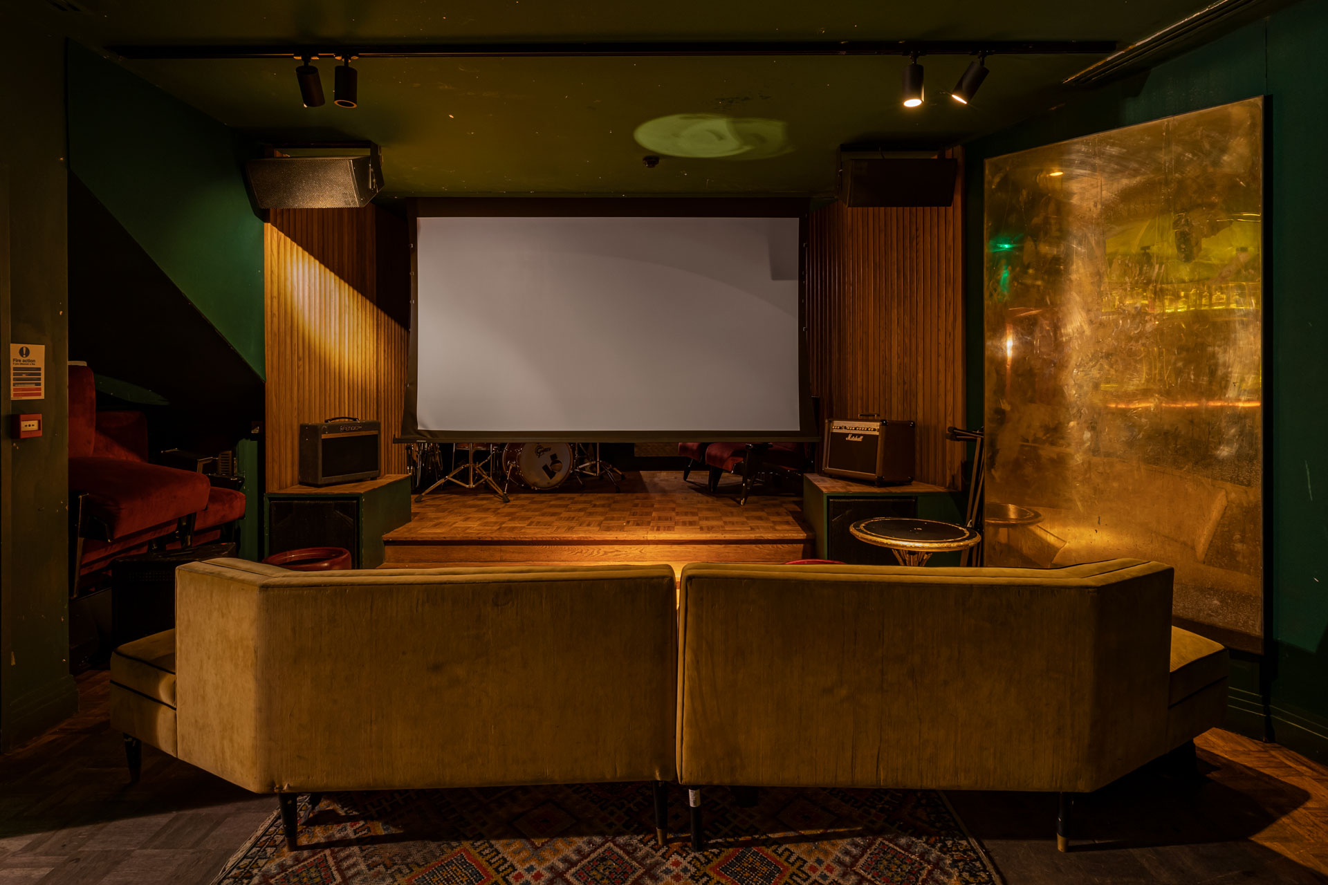 Cinema room with large projector screen and mustard yellow velvet seats
