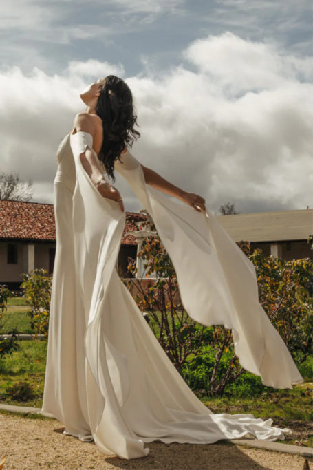 Woman in white dress with head thrown back