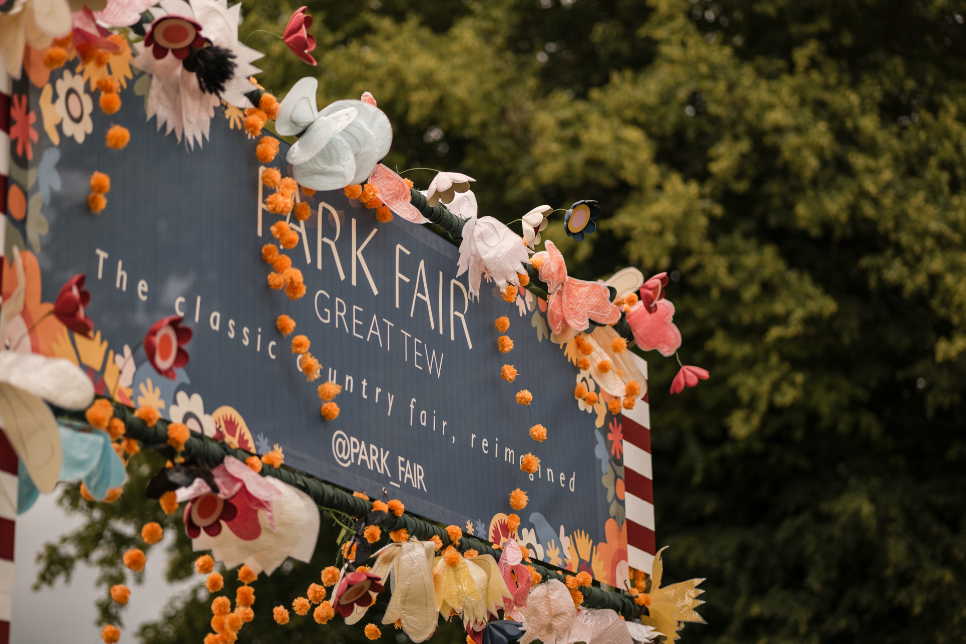 Black Park Fair sign bordered by orange flower garlands