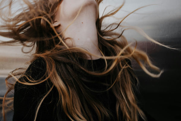 Woman with long shag haircut, with head tipped back