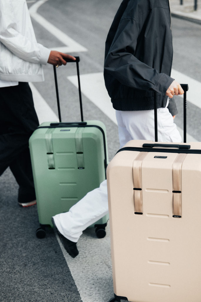 Two people walking with a suitcase each