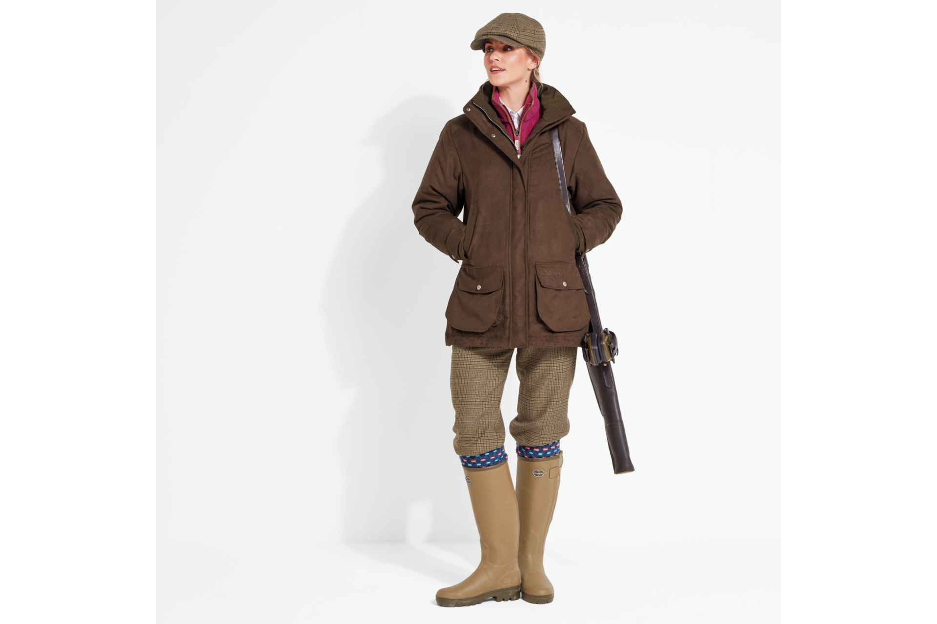 Woman in hunting jacket with gun