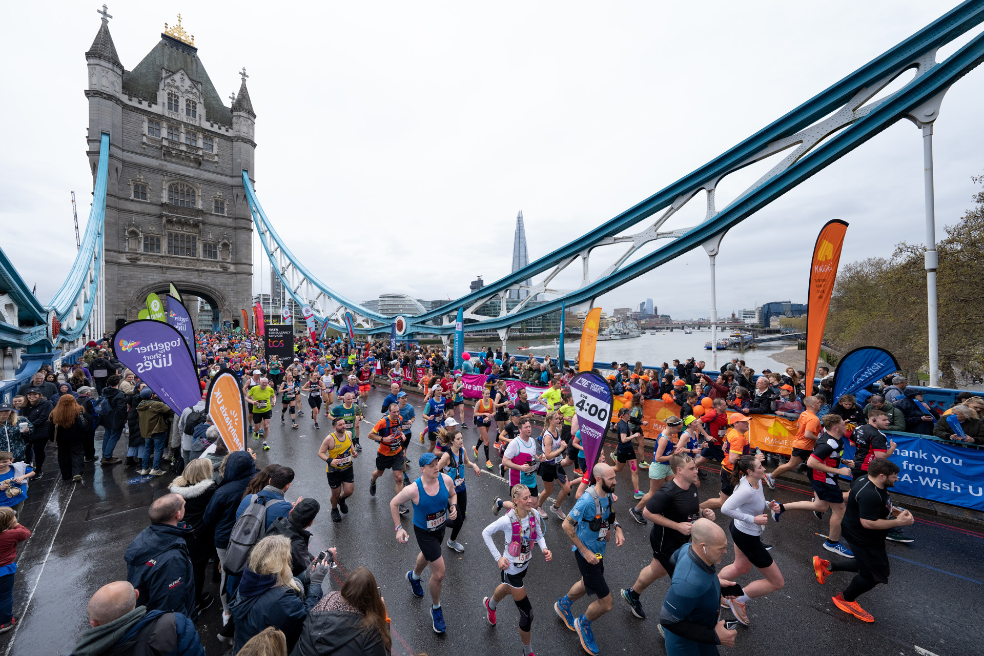 Participants cross Tower Bridge with the sub 4 hour pace runner during The TCS London Marathon on Sunday 23rd April 2023.